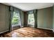 Spacious bedroom featuring hardwood floors, two large windows, and decorative wallpaper at 5356 S U.S. Highway 421, Zionsville, IN 46077