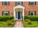 Classic brick home featuring a blue front door, white portico, and manicured landscaping at 5356 S U.S. Highway 421, Zionsville, IN 46077