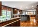 Open kitchen with island, stainless appliances, and wood floors flows into the dining area at 5356 S U.S. Highway 421, Zionsville, IN 46077