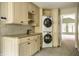 Convenient laundry room area equipped with sink, custom cabinetry, and stacked washer and dryer at 5356 S U.S. Highway 421, Zionsville, IN 46077