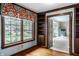 Living room featuring hardwood floors, a large window with custom valance, and built-in bookshelves, providing ample storage at 5356 S U.S. Highway 421, Zionsville, IN 46077