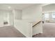 Upstairs hallway with neutral carpet and paint and an open view of a living room with plenty of natural light at 5366 Laurel Crest Run, Noblesville, IN 46062