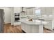 Bright kitchen features white cabinets, quartz countertops, stainless steel appliances, and a central island at 5366 Laurel Crest Run, Noblesville, IN 46062