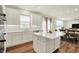Bright kitchen features white cabinets, quartz countertops, stainless steel appliances, and a large island with seating at 5366 Laurel Crest Run, Noblesville, IN 46062