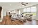 Open living room with large windows, ceiling fan, and hardwood floors at 5366 Laurel Crest Run, Noblesville, IN 46062