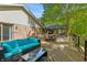Large wooden back deck with a blue outdoor sofa, outdoor furniture set and mature trees providing shade at 5920 Crooked Creek E Dr, Martinsville, IN 46151