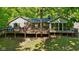 Backyard with large deck with multiple outdoor entertaining spaces surrounded by mature trees at 5920 Crooked Creek E Dr, Martinsville, IN 46151
