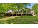 Exterior backyard view showing a large deck with multiple entertaining spaces, surrounded by large, mature trees at 5920 Crooked Creek E Dr, Martinsville, IN 46151