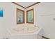 Bright bathroom featuring a tiled jacuzzi tub with jets and two windows letting in natural light at 5920 Crooked Creek E Dr, Martinsville, IN 46151