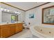 Bright bathroom with dual sinks, a soaking tub, and natural light creating a relaxing space at 5920 Crooked Creek E Dr, Martinsville, IN 46151