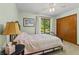 Cozy bedroom with ceiling fan, window view, and bed with pink and white patterned quilt at 5920 Crooked Creek E Dr, Martinsville, IN 46151
