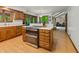 Well-equipped kitchen with an oven and cooktop island, wood cabinets, and an open design to the dining space at 5920 Crooked Creek E Dr, Martinsville, IN 46151