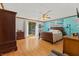 Bright main bedroom with wood floors, large windows, and a soothing teal accent wall and decor at 5920 Crooked Creek E Dr, Martinsville, IN 46151