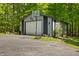 Spacious shed with a roll up door and an asphalt driveway surrounded by trees at 5920 Crooked Creek E Dr, Martinsville, IN 46151