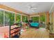 Bright sunroom with wood paneling, a ceiling fan, and expansive windows offering great views of nature at 5920 Crooked Creek E Dr, Martinsville, IN 46151