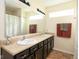 Well-lit bathroom with double sinks, a large mirror, and modern fixtures at 5957 Haywood Ct, Greenwood, IN 46142