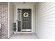 Inviting front door with decorative wreath and sidelight, complemented by charming potted plants at 5957 Haywood Ct, Greenwood, IN 46142