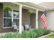 Cozy front porch with hanging plants, seating, and a patriotic American flag display at 5957 Haywood Ct, Greenwood, IN 46142