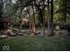 Atmospheric backyard at dusk, showcasing landscaped garden beds, mature trees, and subtle lighting at 5958 Cape Cod Ct, Indianapolis, IN 46250