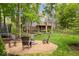 Inviting backyard featuring a fire pit with Adirondack chairs and a lush, tree-lined landscape at 5958 Cape Cod Ct, Indianapolis, IN 46250