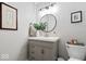 Neutral half-bathroom featuring a single vanity, round mirror, and framed art pieces at 5958 Cape Cod Ct, Indianapolis, IN 46250