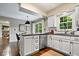 Kitchen area featuring white cabinetry, a breakfast bar, stainless appliances, and wood floors at 5958 Cape Cod Ct, Indianapolis, IN 46250