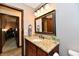 Bathroom featuring a granite vanity, modern fixtures, with a peek into an adjacent room and wood-look flooring at 5979 E Oak Hl Dr, Plainfield, IN 46168