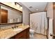 Bathroom vanity featuring granite countertops and a decorative mirror, complimented by a shower with elegant details at 5979 E Oak Hl Dr, Plainfield, IN 46168