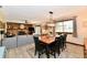 Open-concept dining area features a modern chandelier, wood table, and natural light from the window at 5979 E Oak Hl Dr, Plainfield, IN 46168