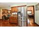Eat-in kitchen features stainless steel refrigerator, wood cabinets, granite countertops, and brick wall detail at 5979 E Oak Hl Dr, Plainfield, IN 46168