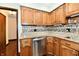 Kitchen features stainless steel dishwasher, wood cabinets, granite countertops and mosaic tile backsplash at 5979 E Oak Hl Dr, Plainfield, IN 46168