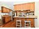 Kitchen view with wood cabinets, granite countertops, stainless steel appliances, and breakfast bar at 5979 E Oak Hl Dr, Plainfield, IN 46168
