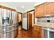 Kitchen shows stainless steel refrigerator, granite countertops, wood cabinets, and doorway to dining room at 5979 E Oak Hl Dr, Plainfield, IN 46168