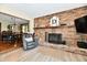 Comfortable living room features a cozy brick fireplace, wood floors, and a seating area at 5979 E Oak Hl Dr, Plainfield, IN 46168