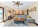 Comfortable living room area featuring wood flooring, a ceiling fan, and sliding door access to outdoor deck at 5979 E Oak Hl Dr, Plainfield, IN 46168