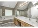 A light-filled bathroom with a double sink vanity, a soaking tub, and a separate shower at 6374 Timberbluff Cir, Avon, IN 46123