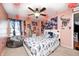 A bedroom with posters on the pink walls, a ceiling fan, and a white bed at 6374 Timberbluff Cir, Avon, IN 46123