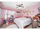 A cheerful bedroom with pink walls, a ceiling fan, and a dollhouse display at 6374 Timberbluff Cir, Avon, IN 46123