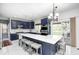 A modern kitchen features blue cabinets, stainless appliances, a white marble countertop island and updated lighting at 6374 Timberbluff Cir, Avon, IN 46123