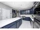Bright kitchen with a large island, stainless appliances, white marble flooring, and plenty of storage in blue cabinets at 6374 Timberbluff Cir, Avon, IN 46123
