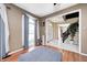 Comfortable sitting area featuring hardwood floors, a large window with sheer curtains, and a view of the foyer at 6374 Timberbluff Cir, Avon, IN 46123