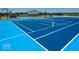 Bright blue tennis court with white lines and netting, ready for games and friendly competition in a sunny setting at 6403 Yuma Ct, Whitestown, IN 46075
