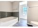 Bathroom featuring a bathtub, toilet, and accent wall at 6491 Enclave Blvd, Greenwood, IN 46143