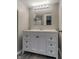 Bathroom featuring a dual sink vanity with storage and large mirror with modern lighting fixture at 6491 Enclave Blvd, Greenwood, IN 46143