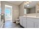 Bright bathroom featuring a double vanity, modern finishes, and a tiled tub surround at 6491 Enclave Blvd, Greenwood, IN 46143