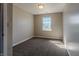 Cozy bedroom with neutral carpet and paint, and window letting in natural light at 6491 Enclave Blvd, Greenwood, IN 46143