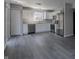 A spacious eat-in kitchen features stainless steel appliances, white cabinets and modern gray wood-look floors at 6491 Enclave Blvd, Greenwood, IN 46143