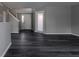 Bright open-concept living room with modern dark wood floors and freshly painted neutral walls at 6491 Enclave Blvd, Greenwood, IN 46143