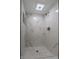 This walk-in shower is completely tiled with marble-look accent tile and features a modern shower head at 6491 Enclave Blvd, Greenwood, IN 46143
