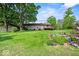 A house with a large grassy backyard, tall trees, and outdoor deck at 665 Spring Hills Dr, Zionsville, IN 46077
